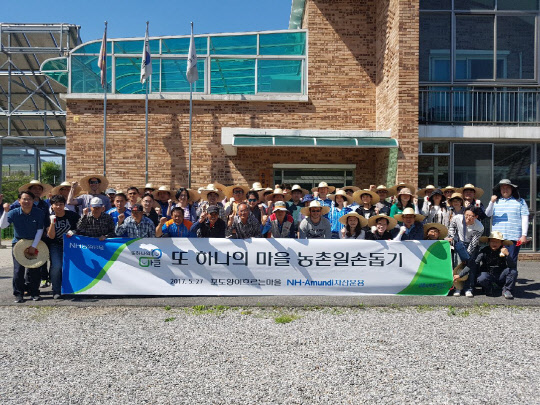 NH-아문디자산운용 임직원들이 지난 27일 가평군 율길1리에서 일손돕기 봉사활동을 실시한 후 기념촬영을 하고 있다. NH-아문디자산운용 제공.